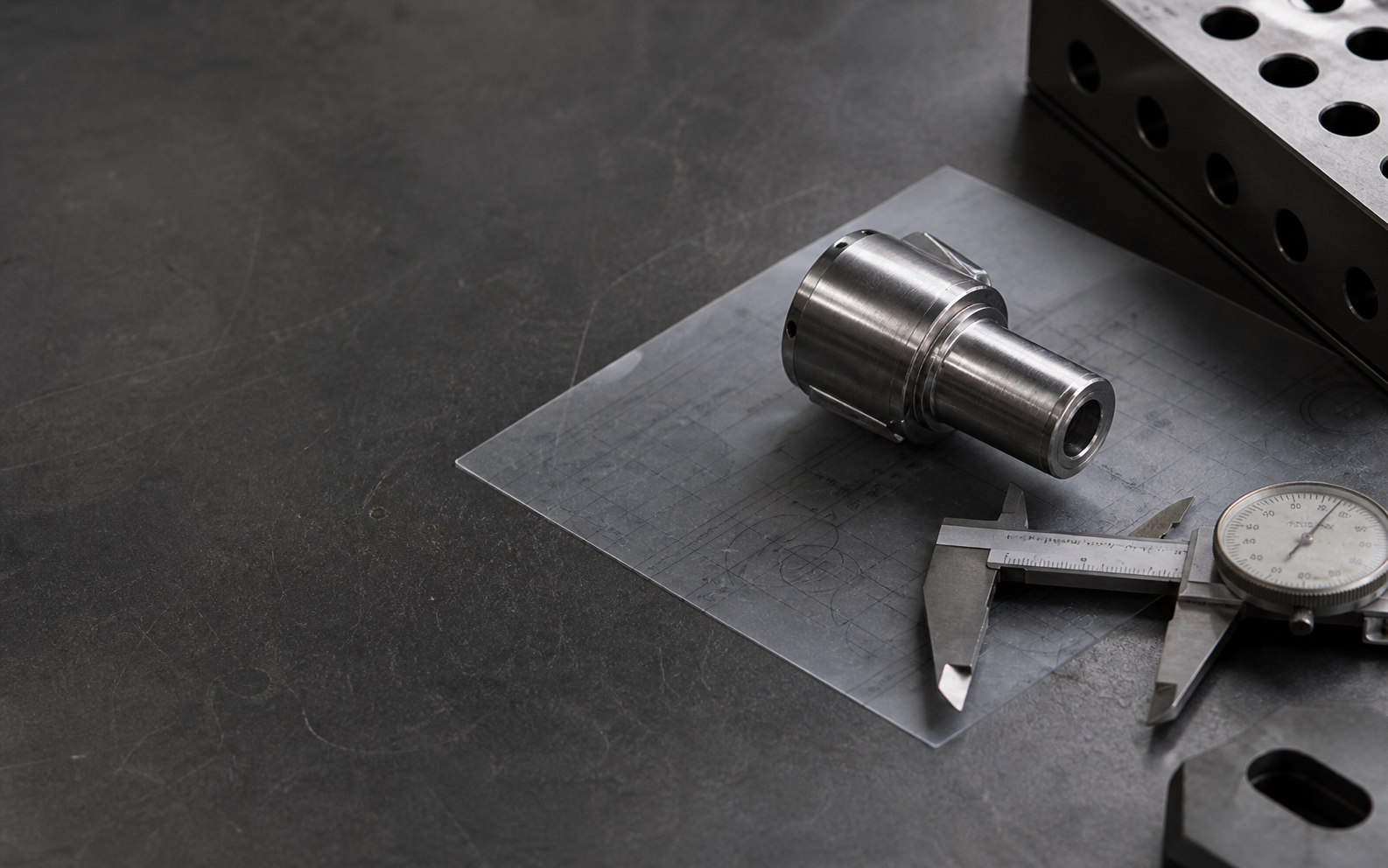 Inspection tools and a machined sample arranged on a mineral-grey workbench